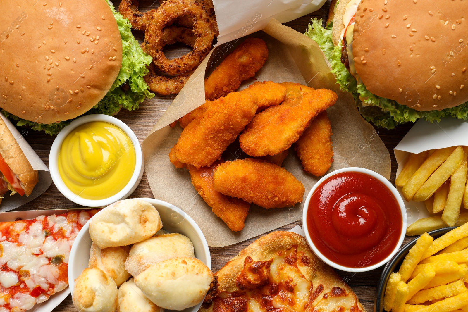 Photo of French fries, burgers and other fast food as background, top view