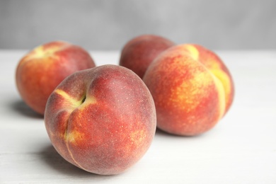 Photo of Fresh juicy peaches on white wooden table