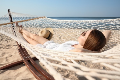 Photo of Young woman relaxing in hammock on beach