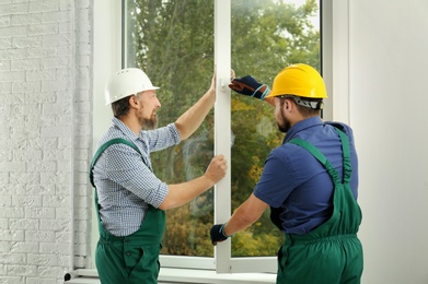 Construction workers installing new window in house