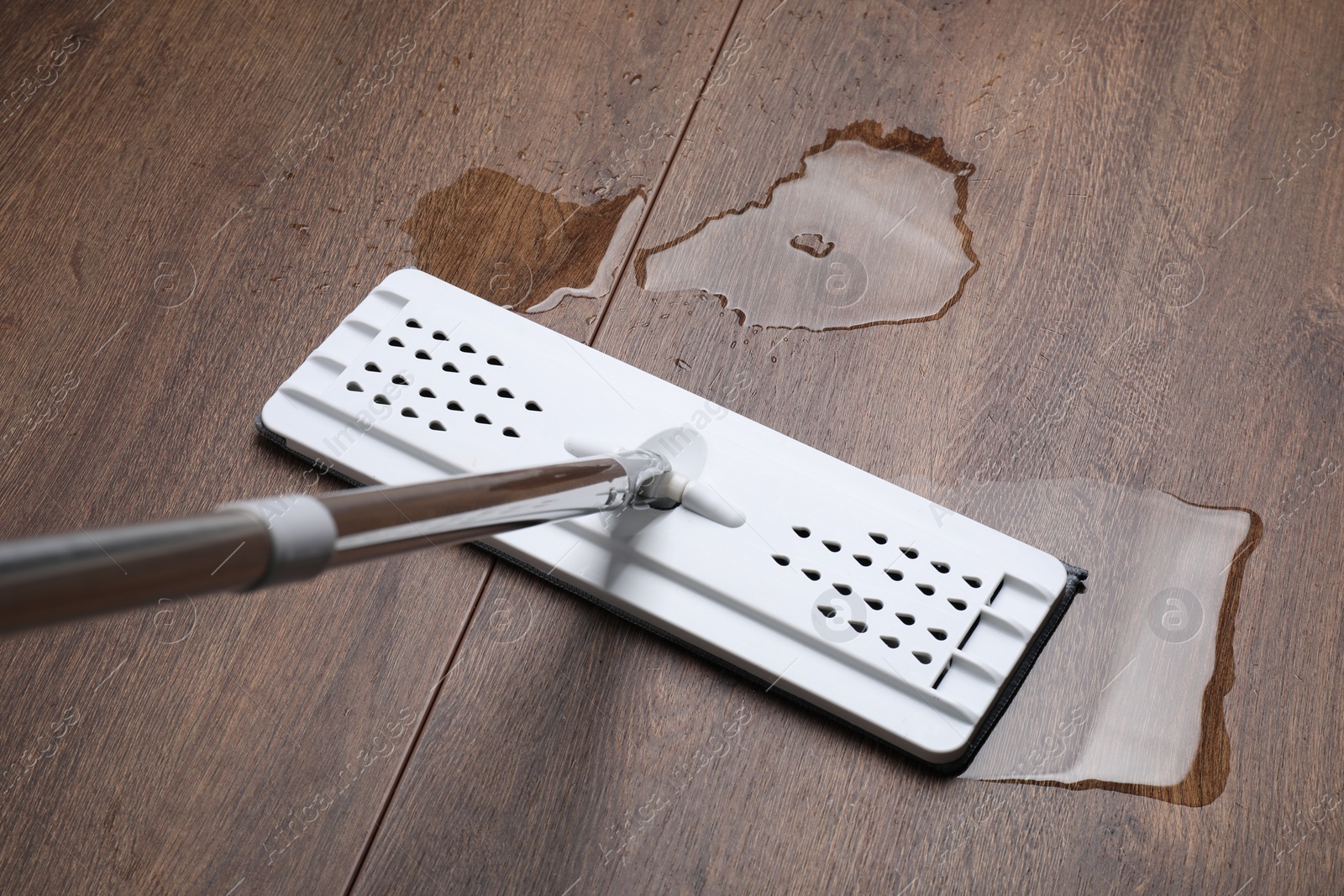 Photo of Cleaning dirty parquet floor with mop, above view