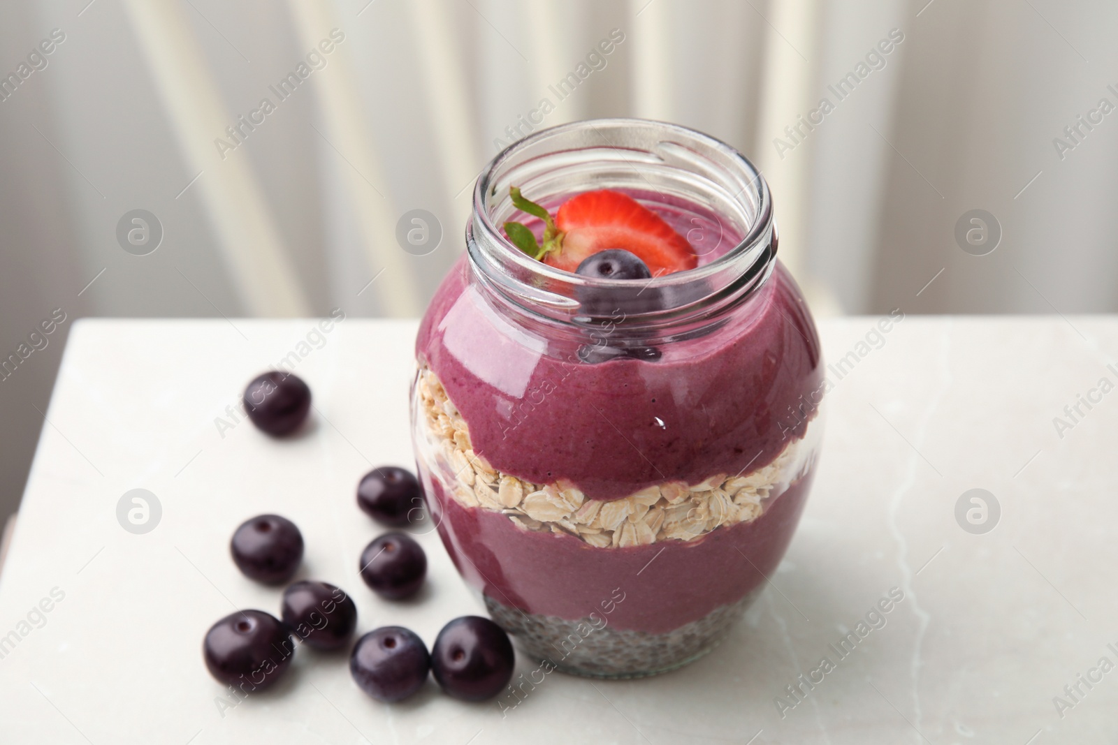 Photo of Jar of tasty acai smoothie on light table