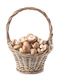 Photo of Wicker basket with fresh raw champignon mushrooms on white background