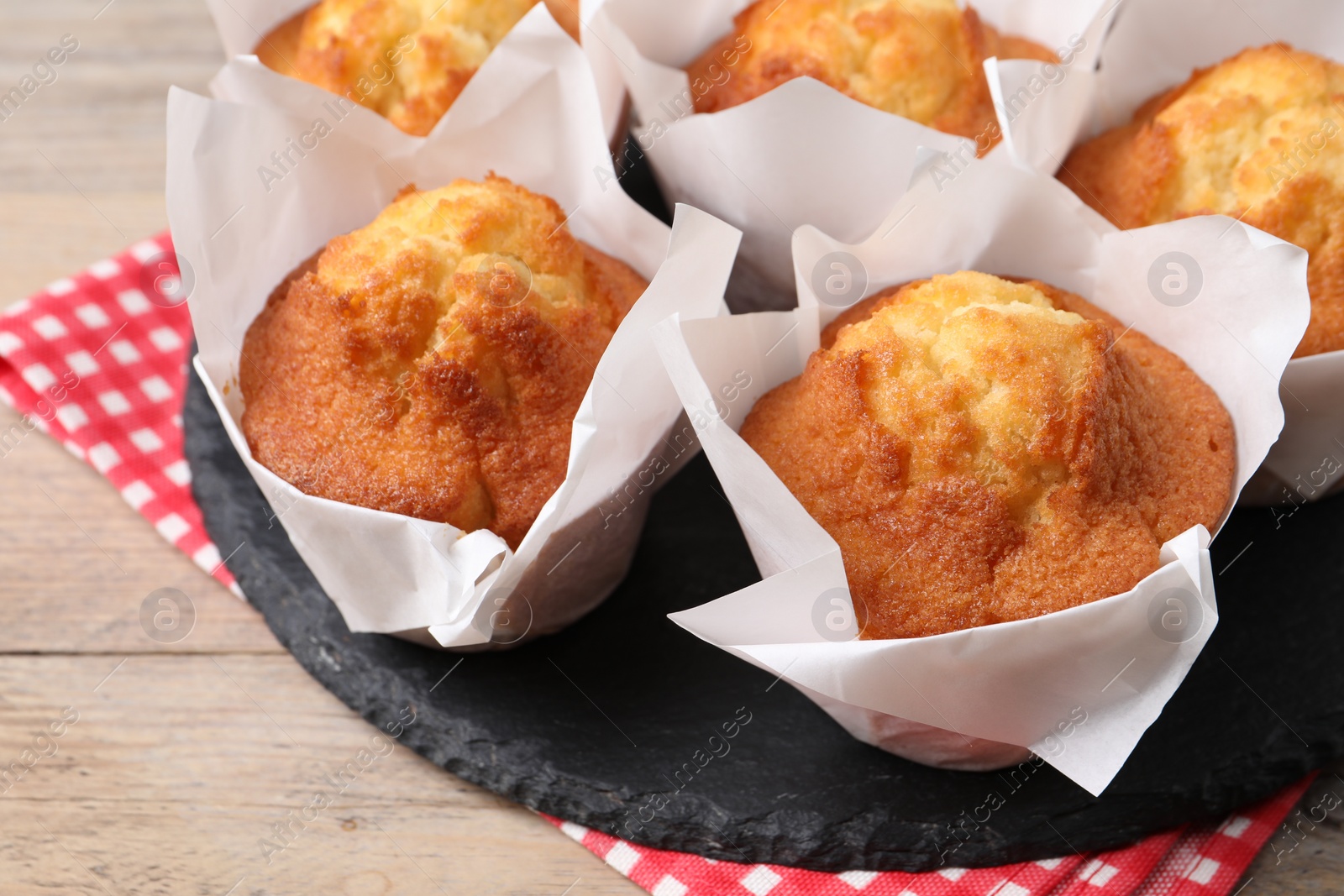 Photo of Delicious sweet muffins on wooden table, closeup