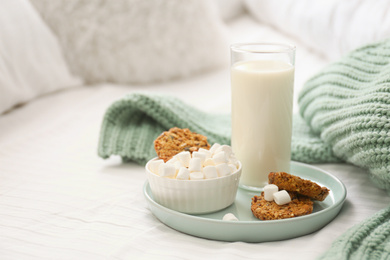 Cookies, marshmallows and milk on bed. Delicious morning meal