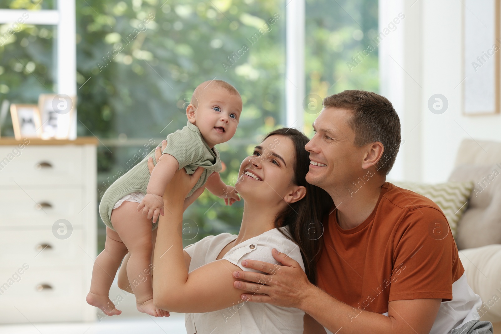 Photo of Portrait of happy family with their cute baby at home