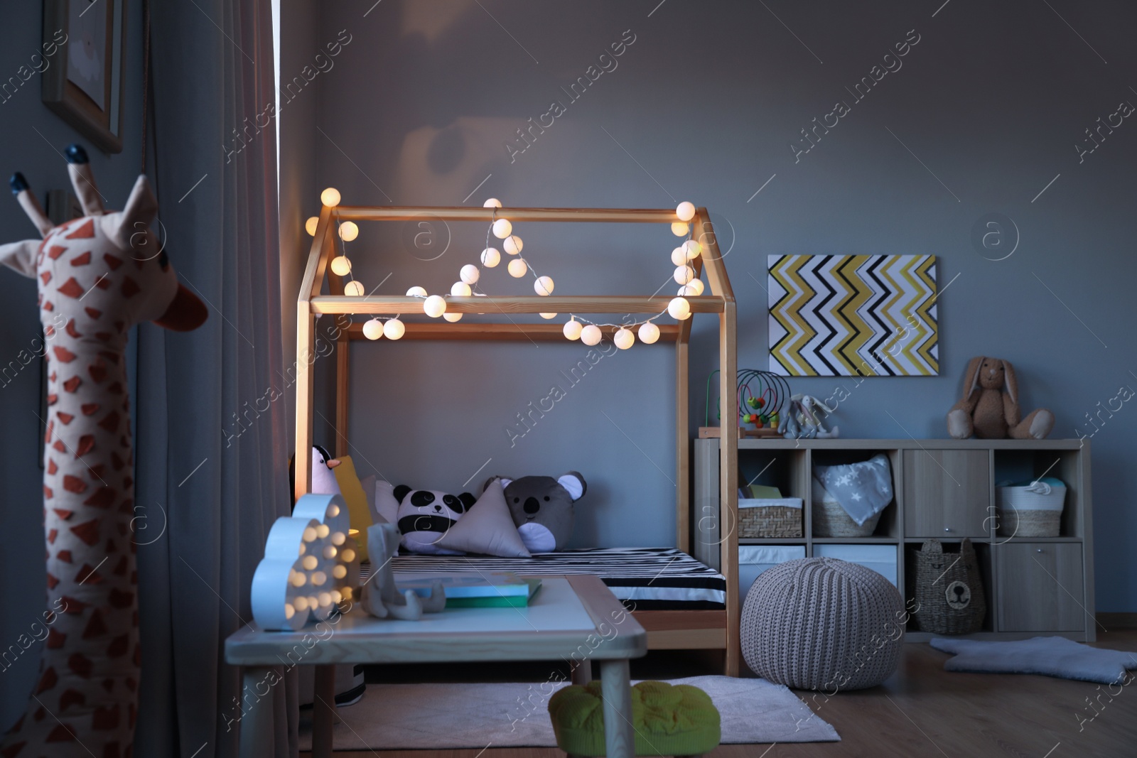 Photo of Stylish child room interior with comfortable house bed and toys