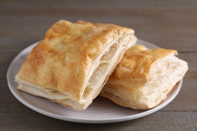 Delicious fresh puff pastries on wooden table, closeup