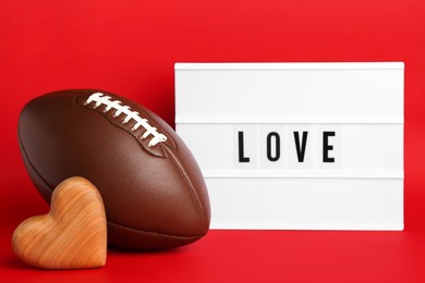 Photo of American football ball, lightbox with word Love and heart on red background