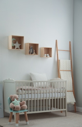 Stylish baby room interior with crib and toys