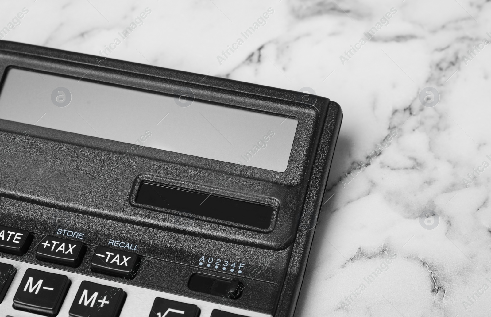 Photo of Calculator on white marble background, closeup. Tax accounting concept