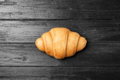 Photo of Tasty croissant on wooden background, top view