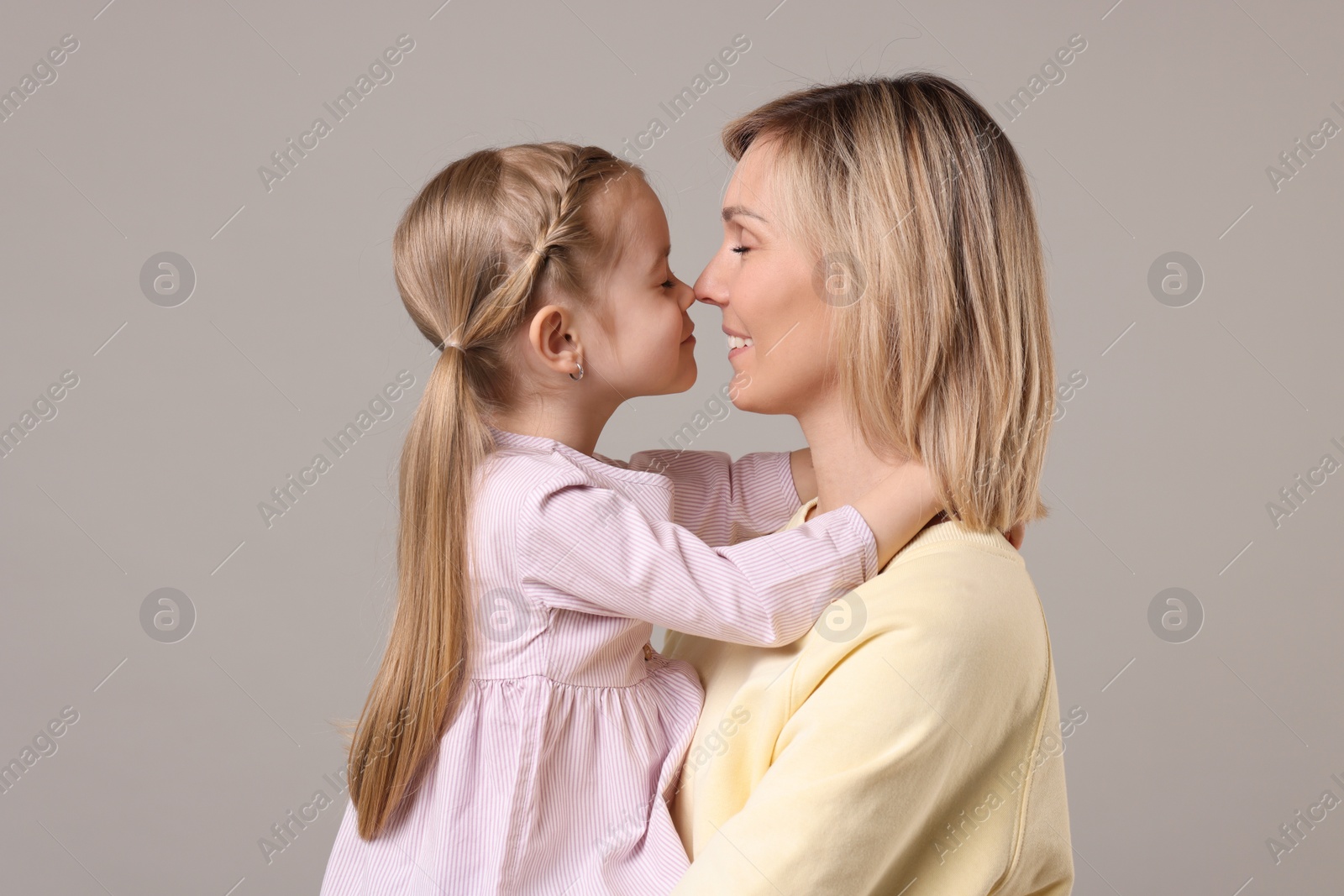 Photo of Family portrait of happy mother and daughter on grey background