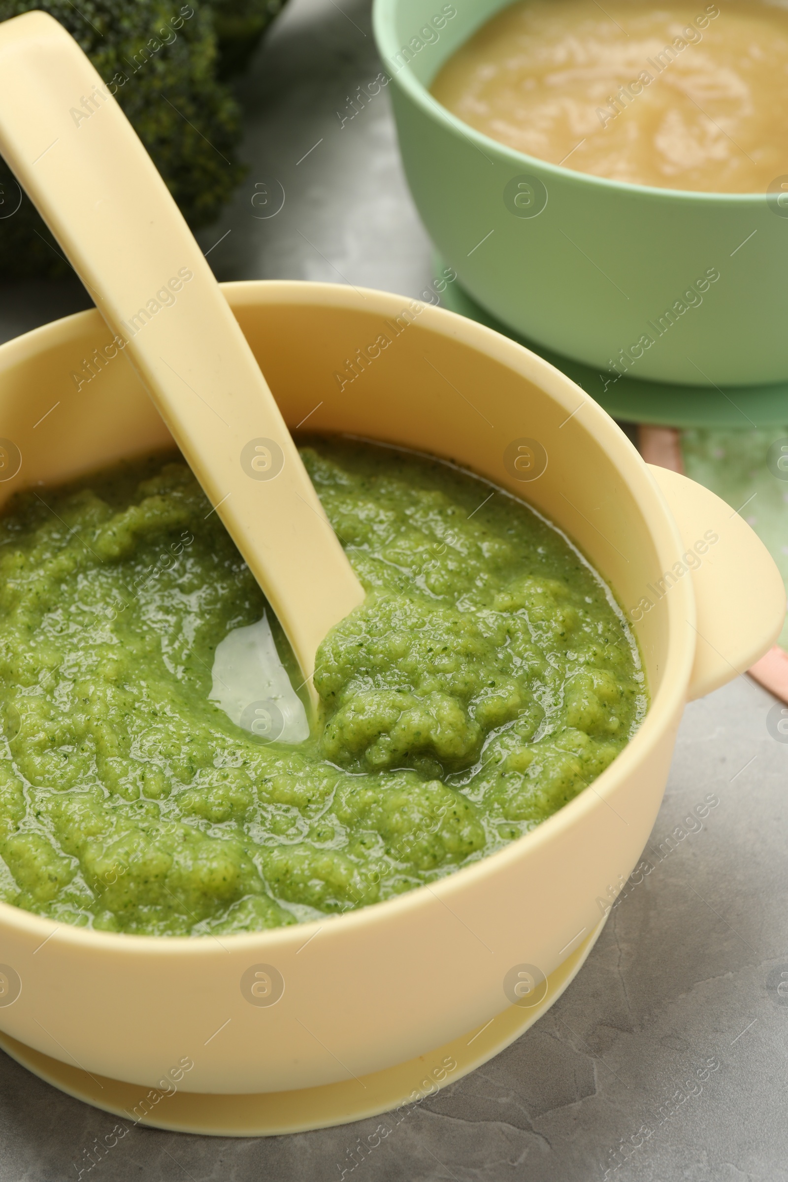 Photo of Healthy baby food. Different tasty puree in bowls on light grey table, closeup