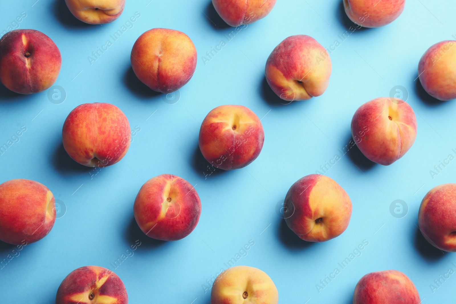 Photo of Fresh ripe peaches on light blue background, flat lay