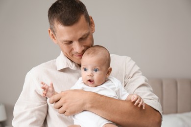 Photo of Happy father holding his cute baby at home