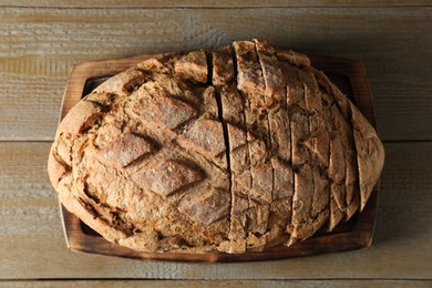 Photo of Freshly baked cut sourdough bread on wooden table