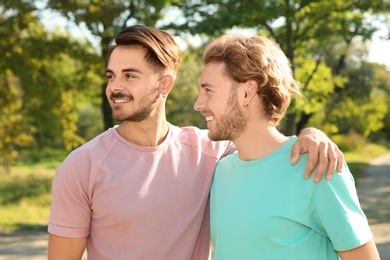 Portrait of happy gay couple smiling in park