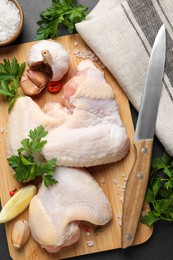 Flat lay composition with fresh raw chicken wings on black table