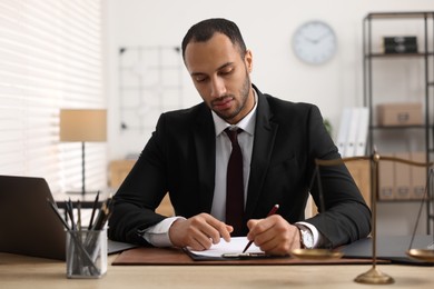 Photo of Serious lawyer working at table in office