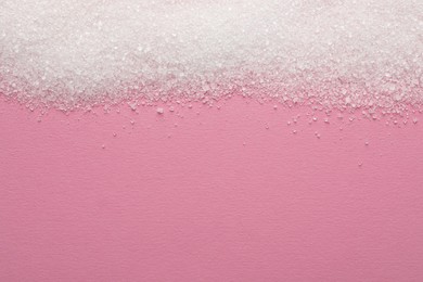 Granulated sugar on pink background, top view. Space for text