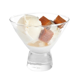 Glass dish of delicious ice cream with caramel candies on white background