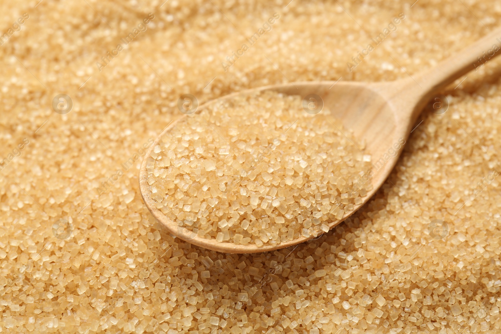 Photo of Spoon on granulated brown sugar, closeup view