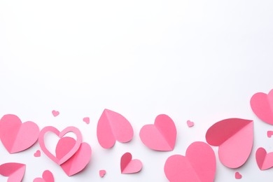 Photo of Pink paper hearts on white background, flat lay. Space for text