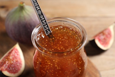 Photo of Glass jar with tasty sweet jam and fresh figs on table, closeup