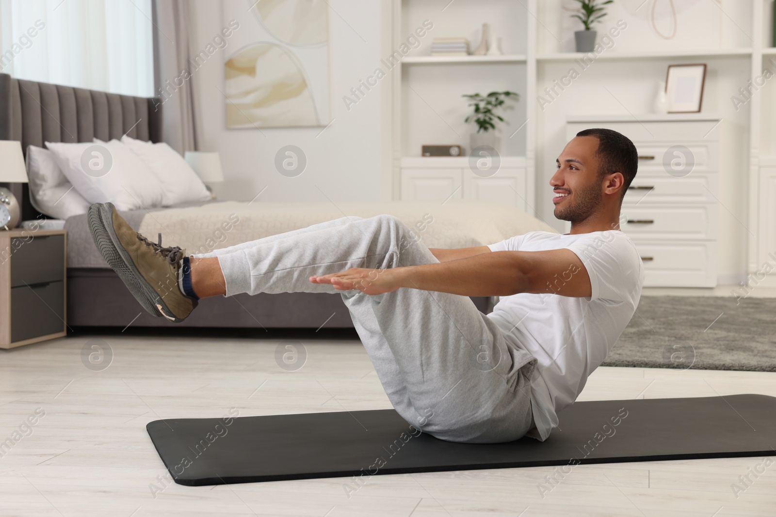 Photo of Man doing morning exercise on fitness mat at home