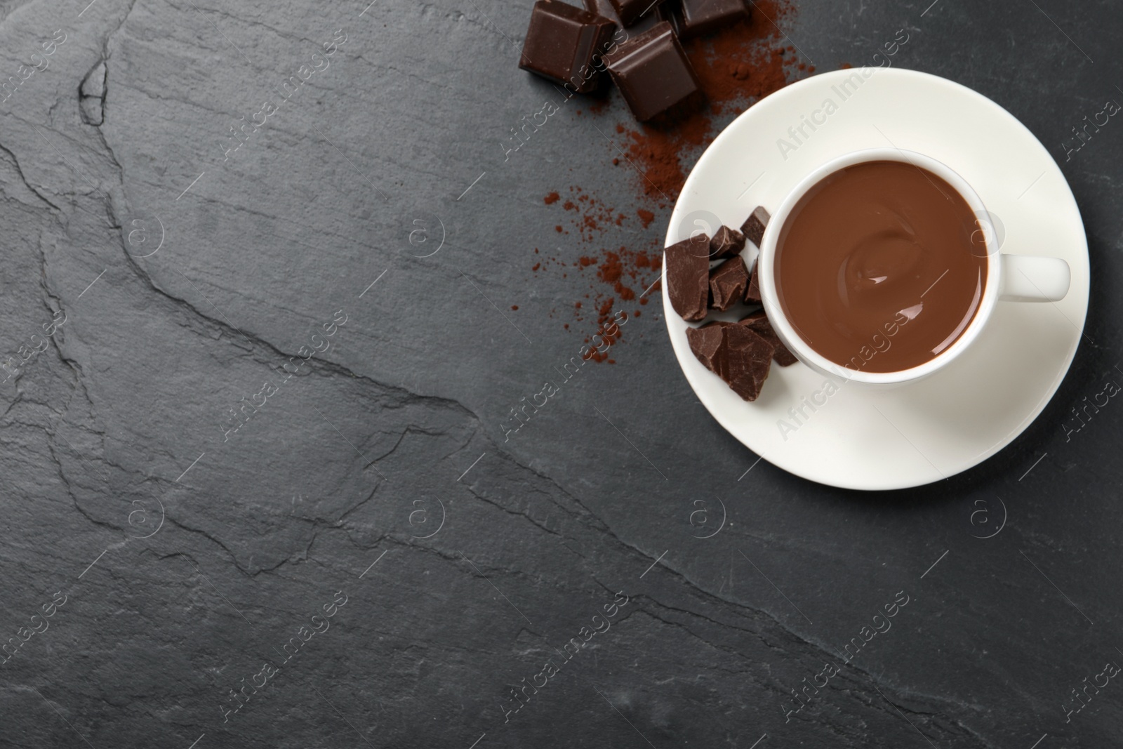 Photo of Yummy hot chocolate in cup on dark table, flat lay. Space for text