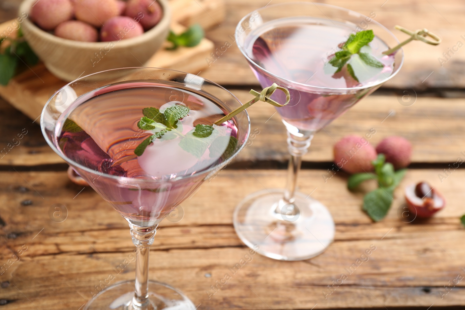 Photo of Tasty lychee cocktail on wooden table, closeup