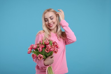 Beautiful young woman on light blue background