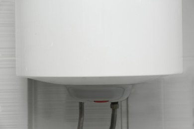 Photo of White water heating tank indoors. Boiler installation