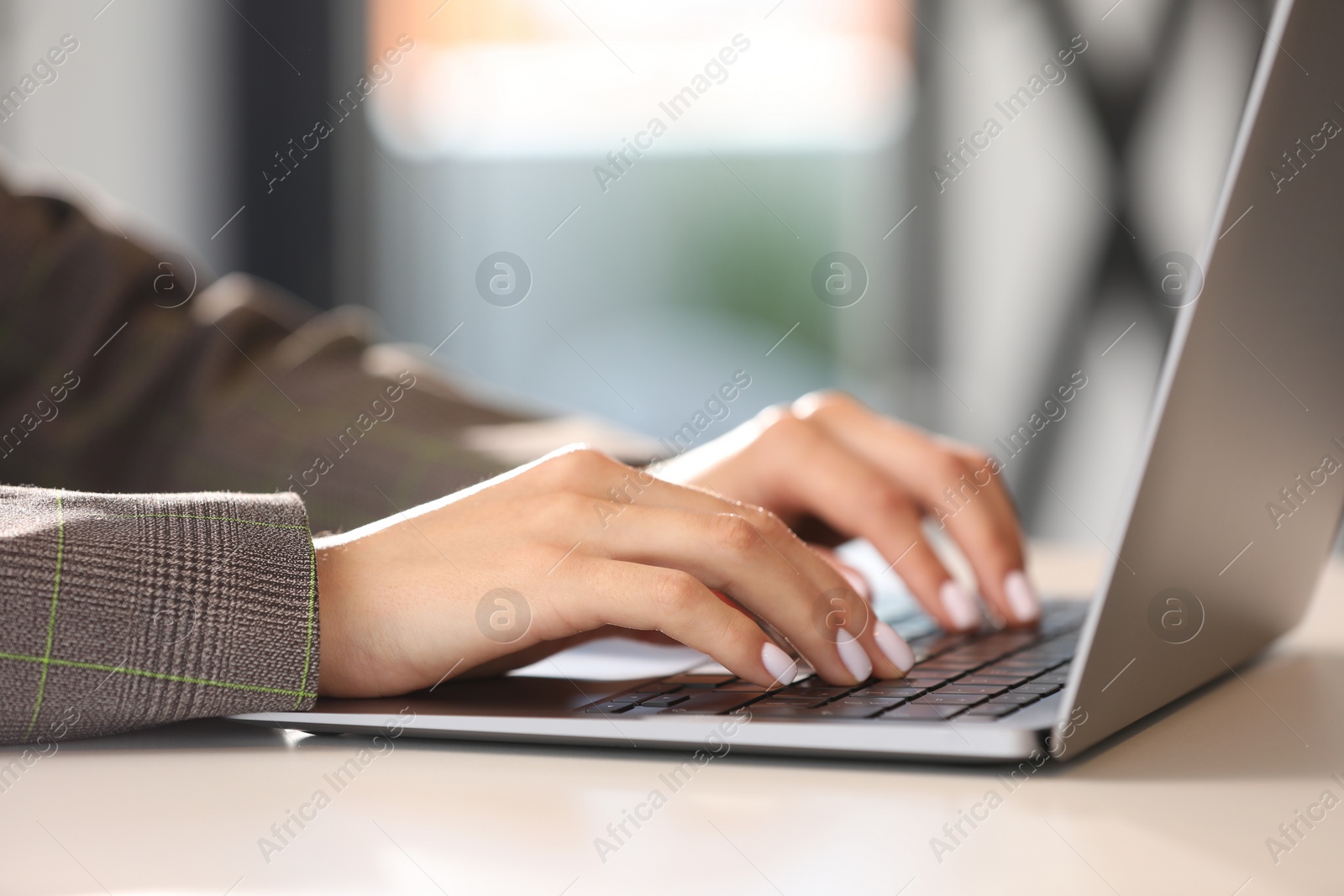 Photo of Woman using modern laptop at desk in office, closeup