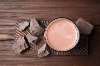 Fresh yummy chocolate milk on wooden table, top view