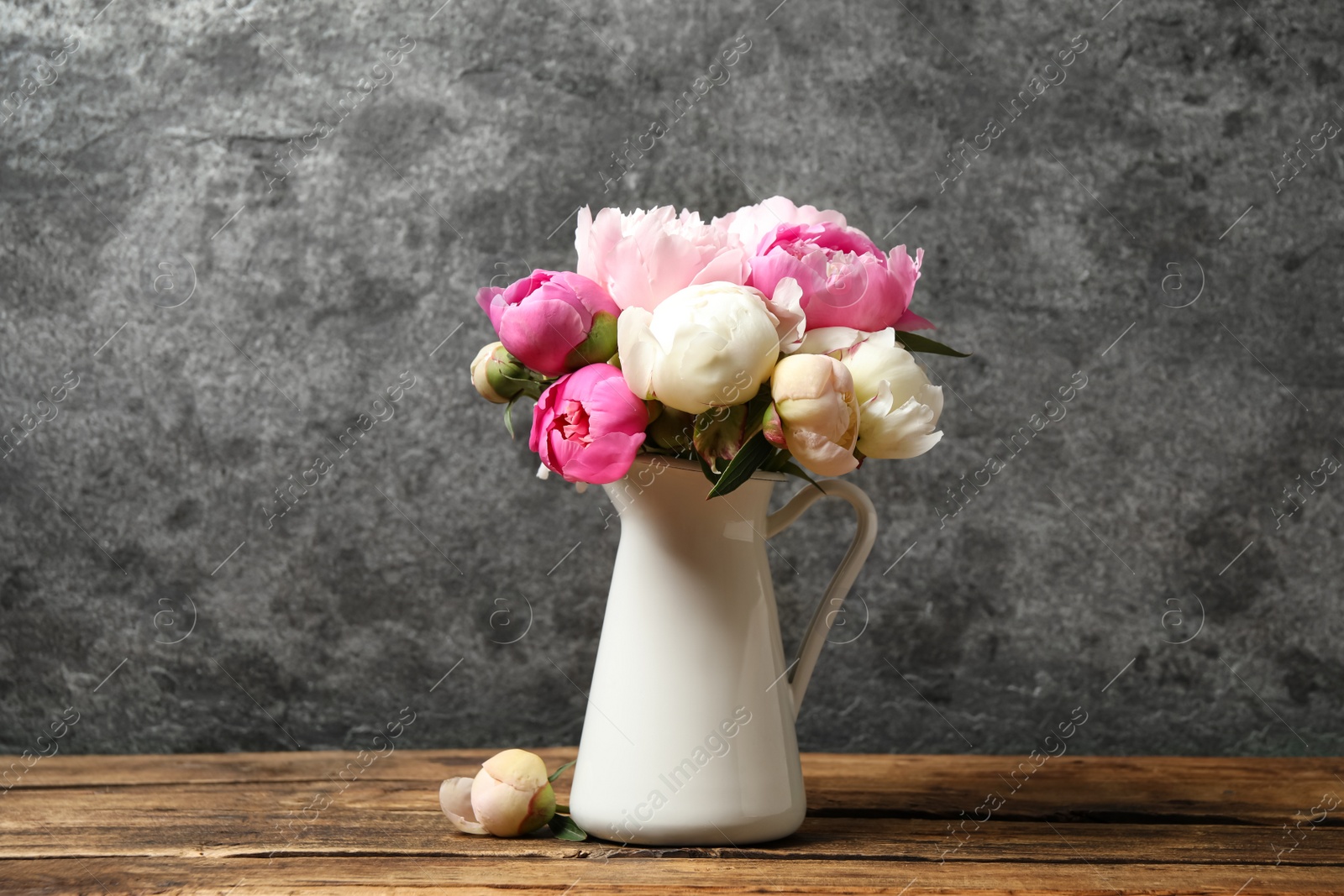 Photo of Bouquet of beautiful peonies in vase on wooden table