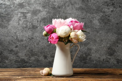 Bouquet of beautiful peonies in vase on wooden table