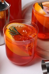 Photo of Aperol spritz cocktail, rosemary and orange slices on white wooden table, closeup