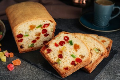 Delicious cake with candied fruits on grey table