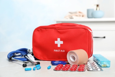 Photo of First aid kit with pills on table indoors