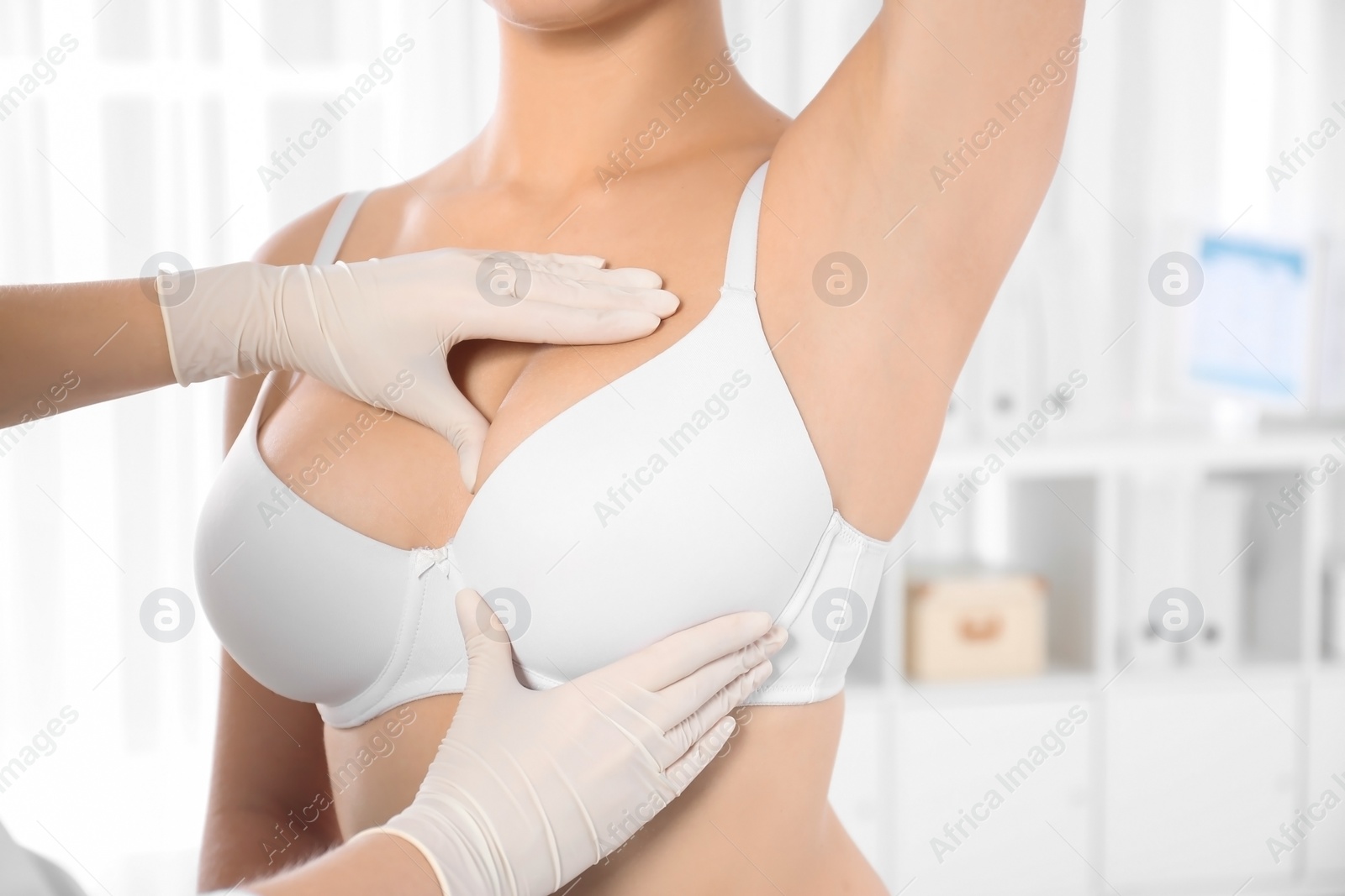 Photo of Doctor checking woman's breast at hospital, closeup