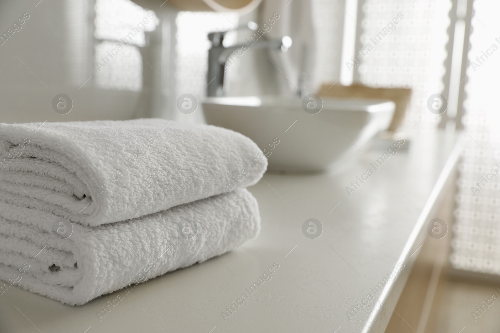 Photo of Stack of clean towels on countertop in bathroom. Space for text