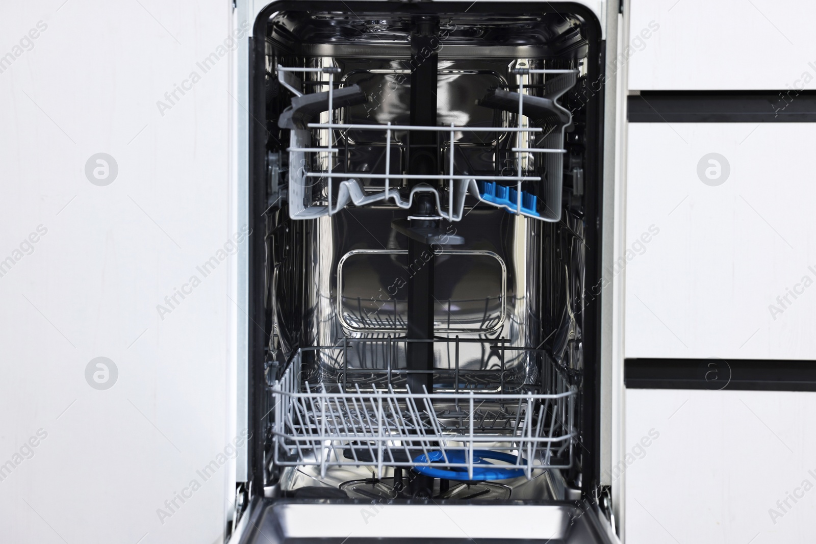 Photo of Open clean empty dishwasher machine. Home appliance