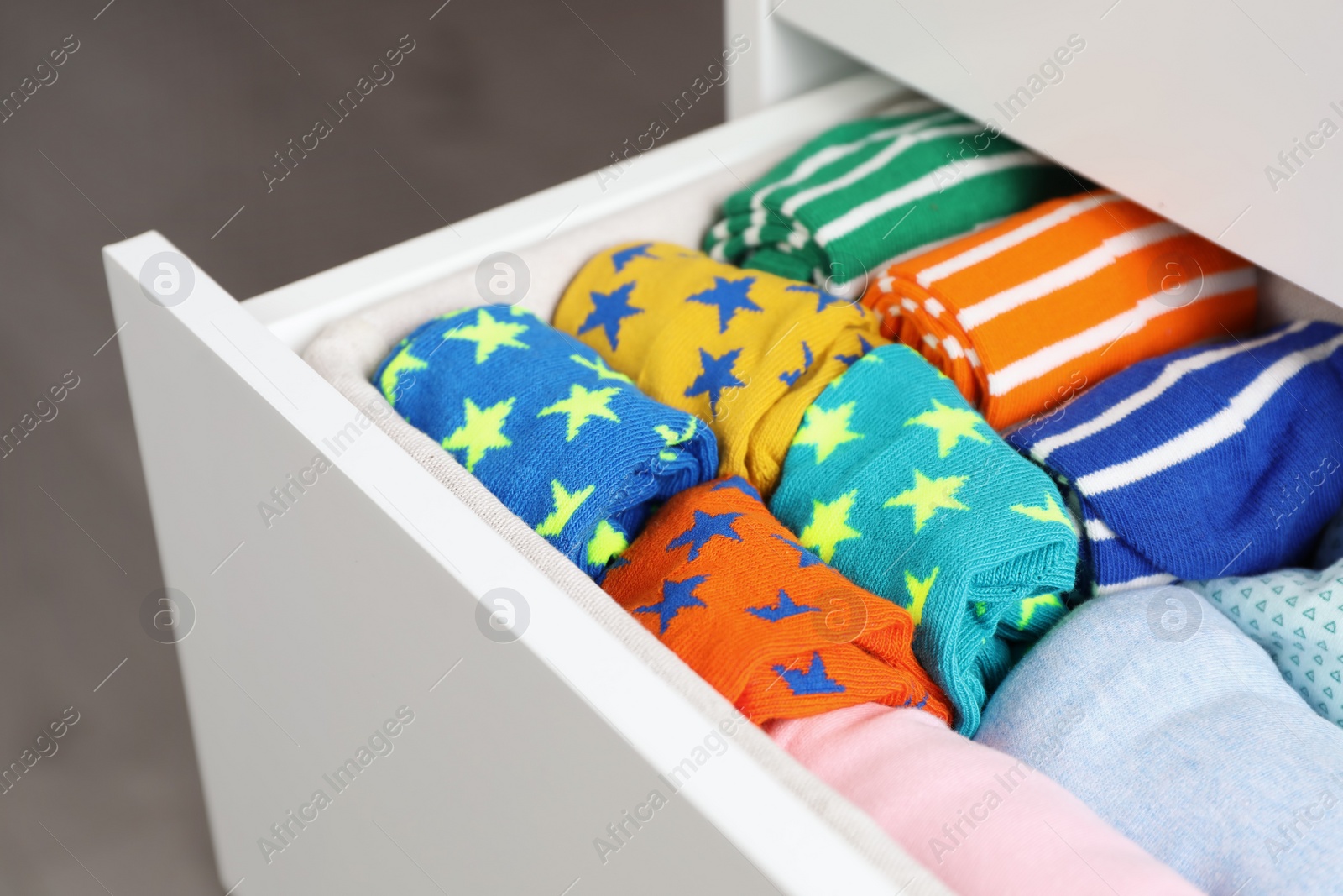 Photo of Many different colorful socks in open drawer, closeup