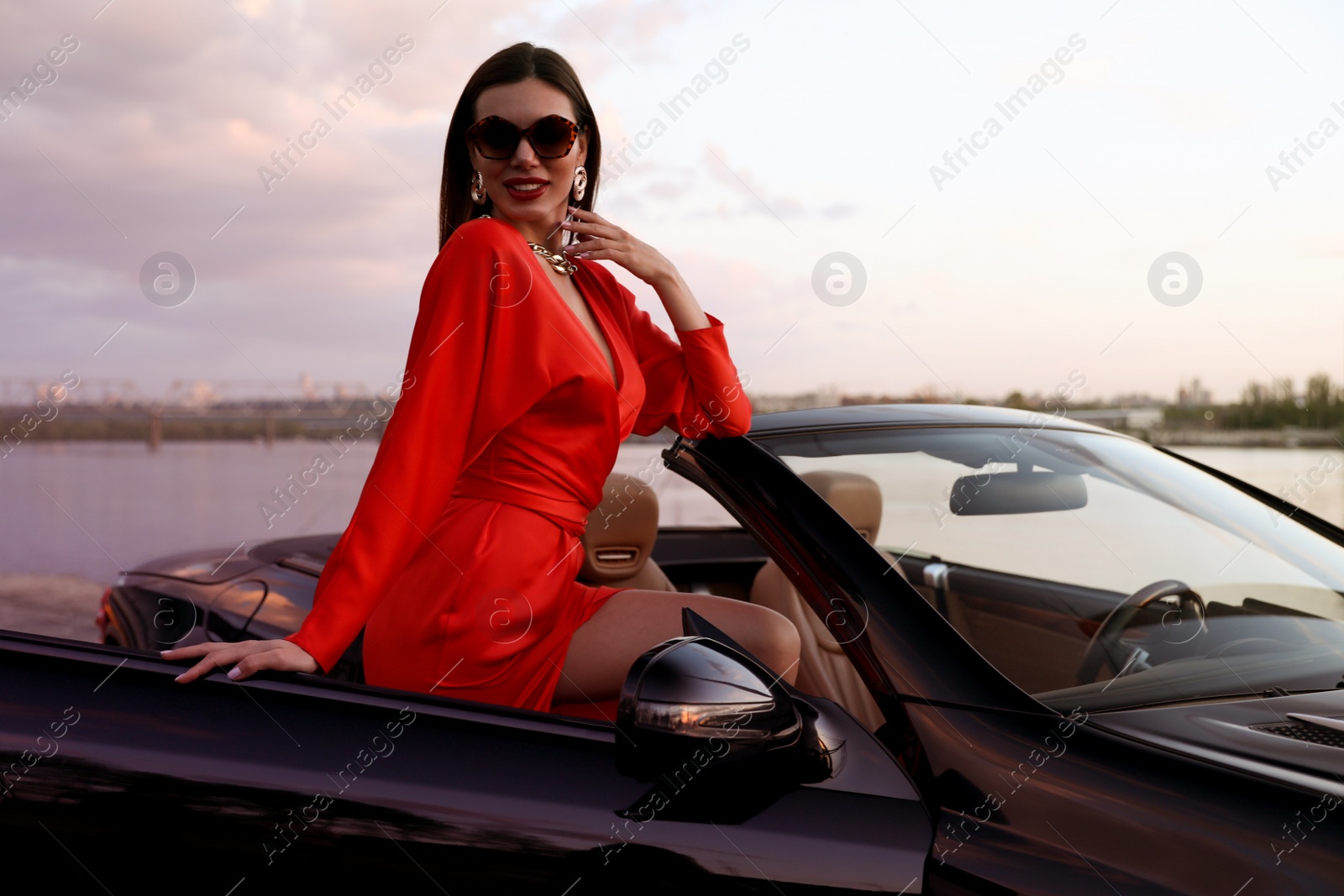 Photo of Sexy woman in luxury convertible car outdoors