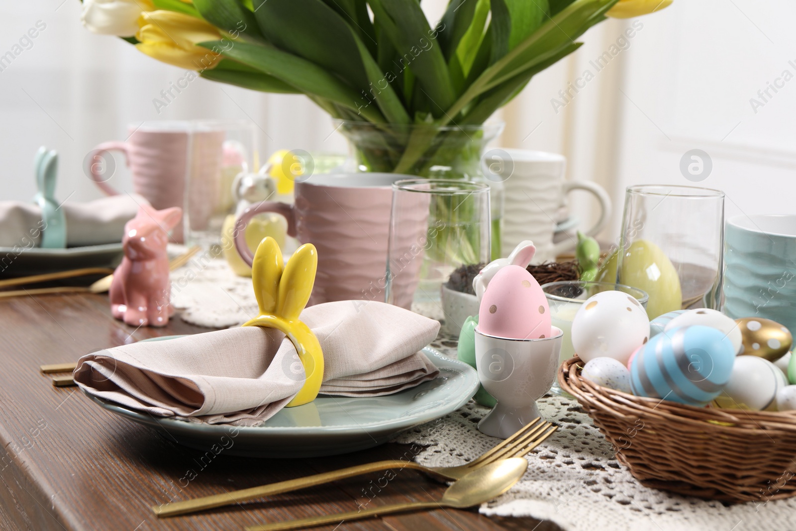 Photo of Festive table setting with napkin ring in shape of bunny ears, closeup. Easter celebration