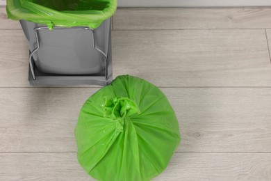 Photo of Plastic garbage bag and trash can indoors, above view