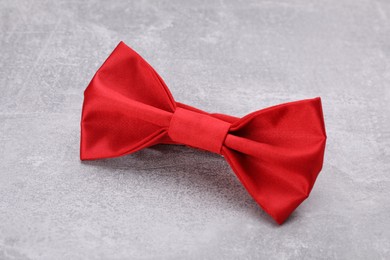 Photo of Stylish red bow tie on light grey table