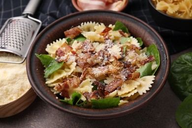 Photo of Tasty pasta with bacon and basil on brown table